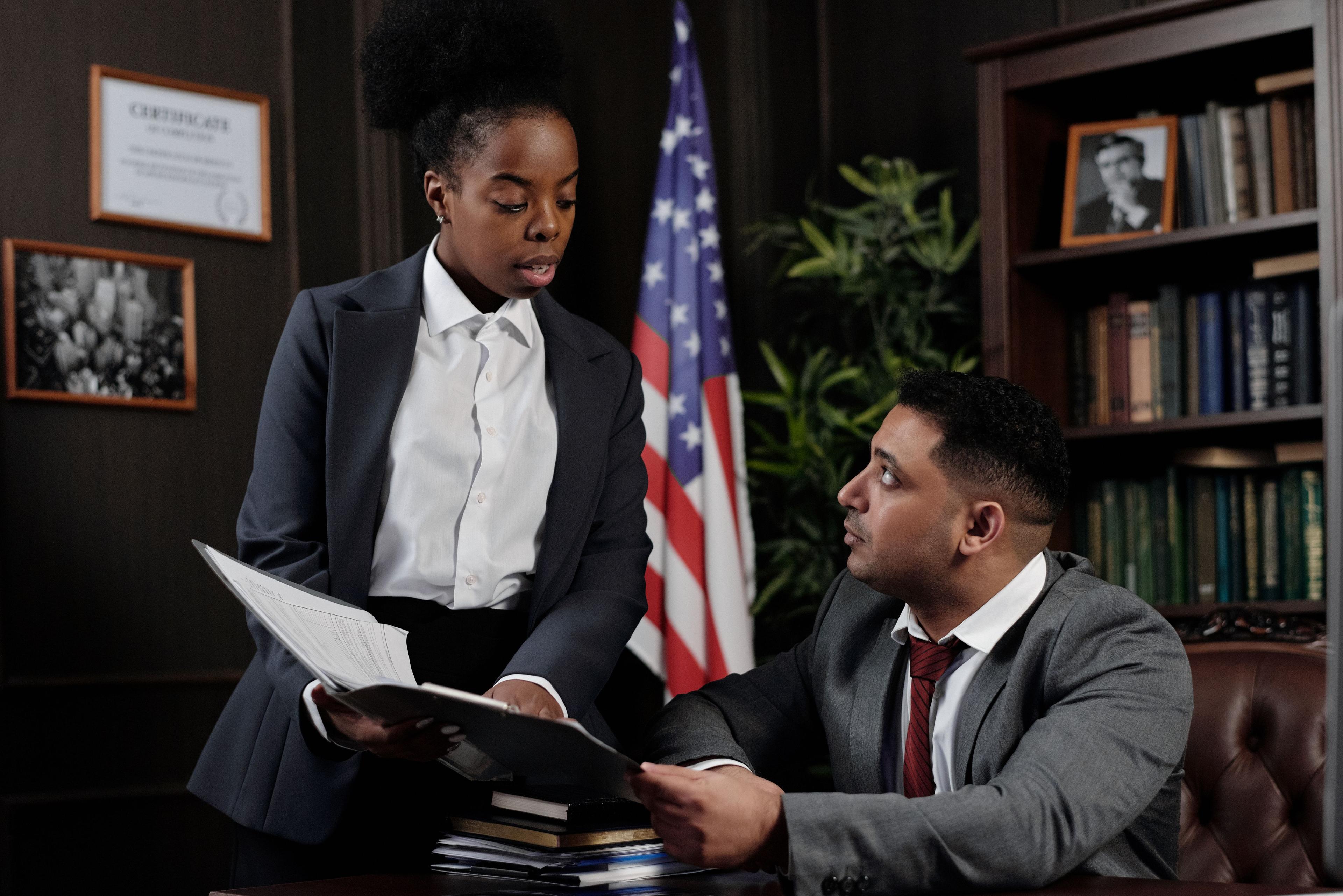 Professionals reviewing country research documents and notes at a desk